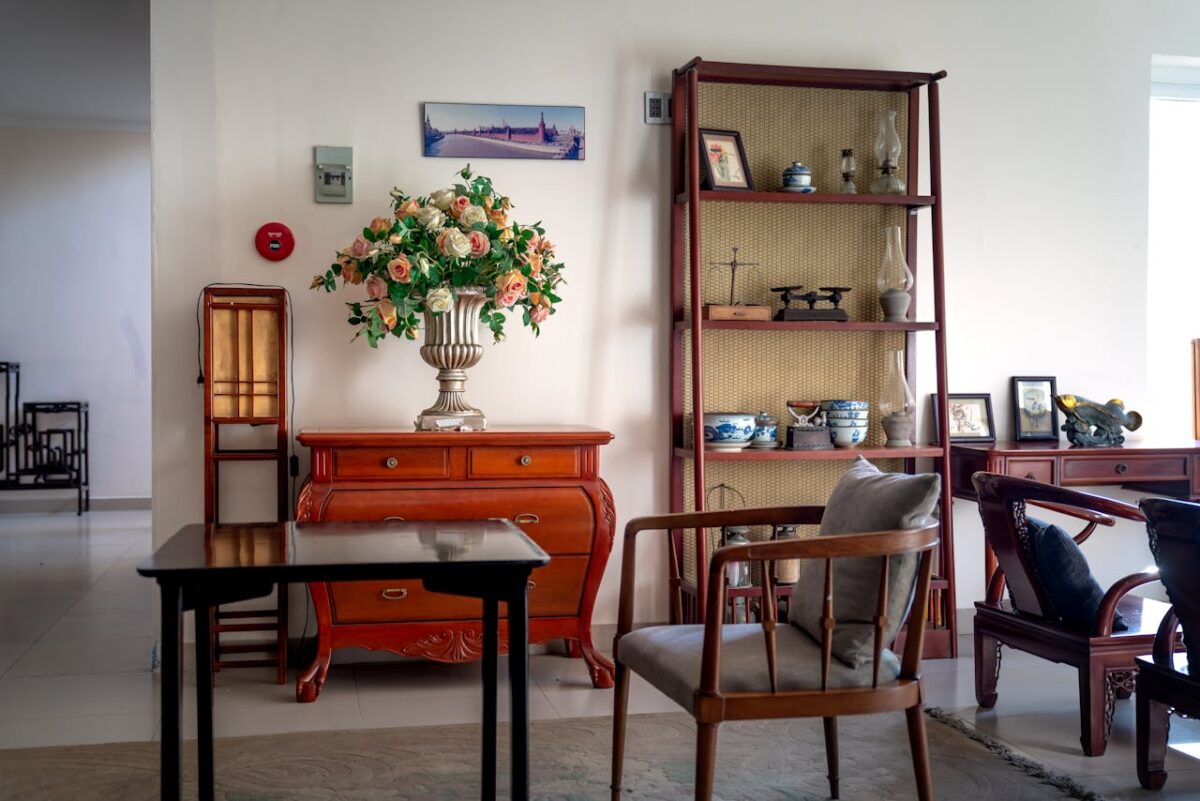services-01 Classic living room interior featuring a floral bouquet, wooden furniture, and decorative ceramics.
